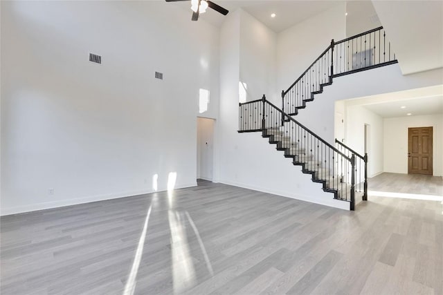 unfurnished living room featuring ceiling fan and light wood-type flooring