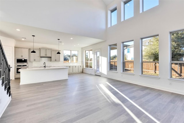 unfurnished living room with sink and light wood-type flooring