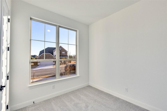 spare room featuring light colored carpet