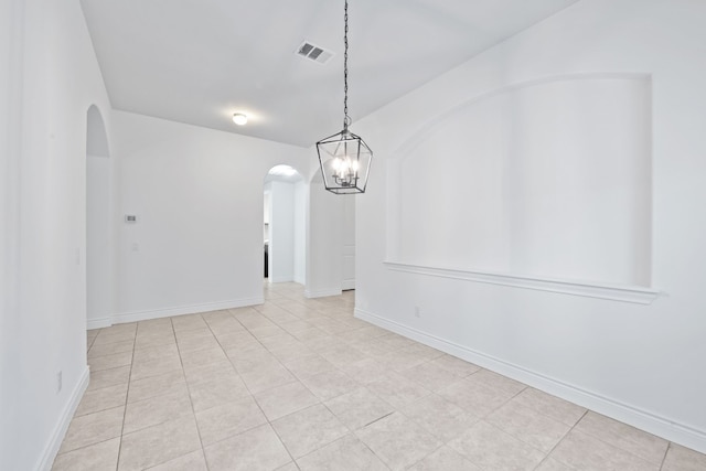 unfurnished dining area featuring light tile patterned floors and a notable chandelier