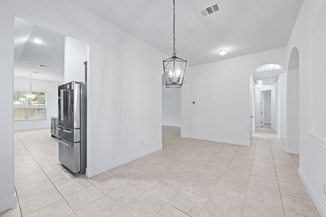 interior space with light tile patterned floors and an inviting chandelier