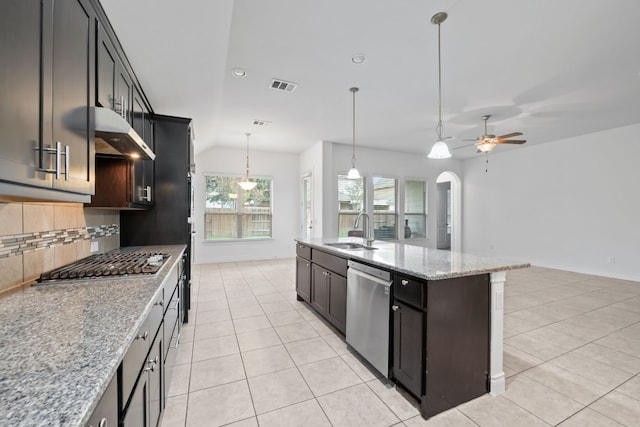 kitchen with light stone counters, sink, a kitchen island with sink, exhaust hood, and appliances with stainless steel finishes