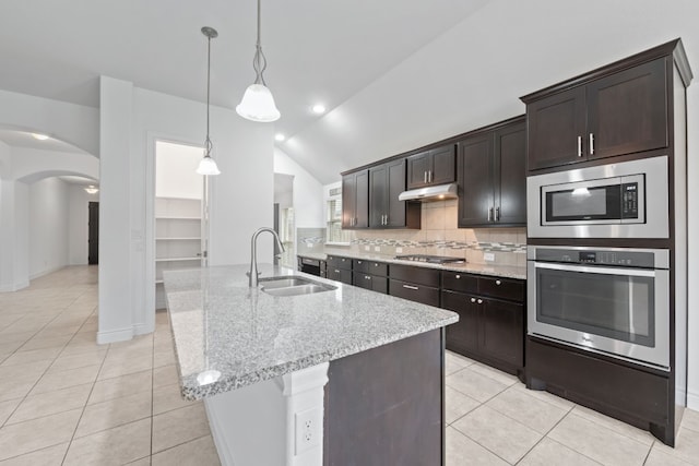 kitchen with lofted ceiling, dark brown cabinetry, hanging light fixtures, sink, and appliances with stainless steel finishes