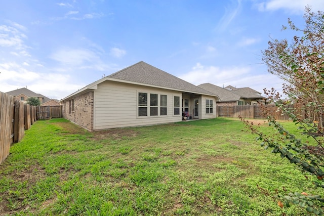 rear view of house featuring a lawn