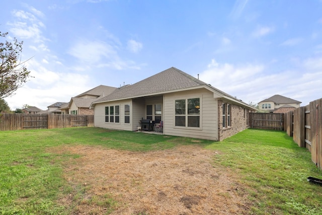 rear view of property featuring a yard