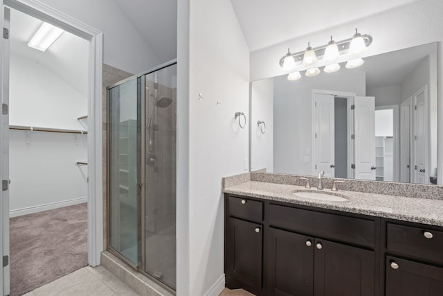 bathroom featuring lofted ceiling, vanity, and a shower with door