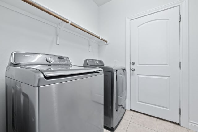 laundry area with light tile patterned floors and washer and dryer