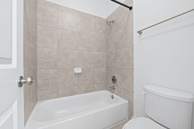 bathroom with toilet and tiled shower / bath combo