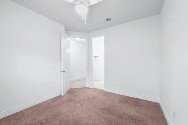 spare room featuring light carpet and ceiling fan