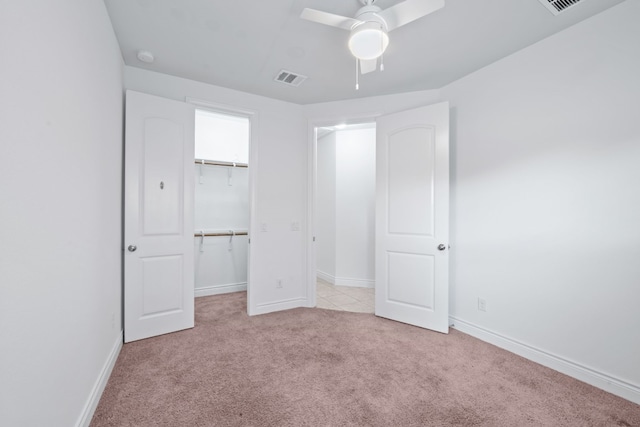 unfurnished bedroom with a closet, light carpet, and ceiling fan