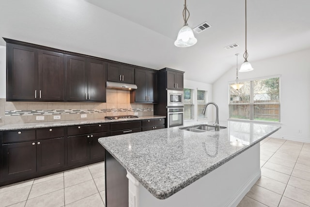 kitchen featuring stainless steel appliances, sink, lofted ceiling, and an island with sink