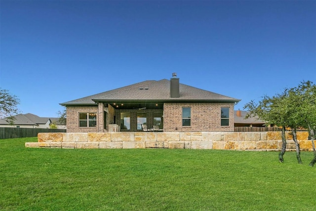 rear view of property featuring a lawn