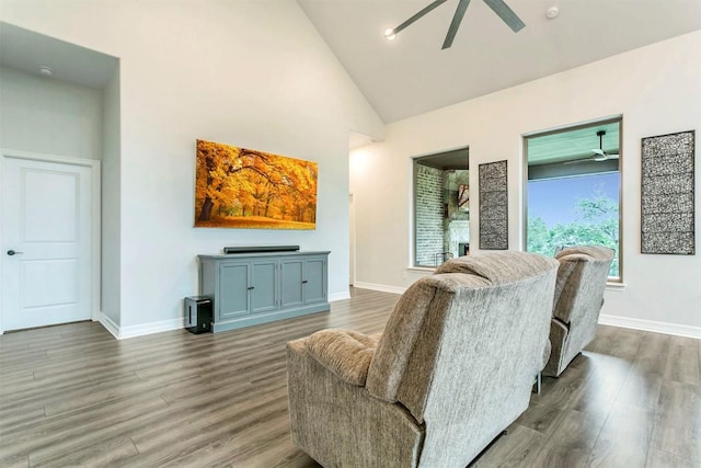 living room with ceiling fan, high vaulted ceiling, and dark wood-type flooring