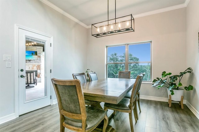 dining space with light wood-type flooring and ornamental molding