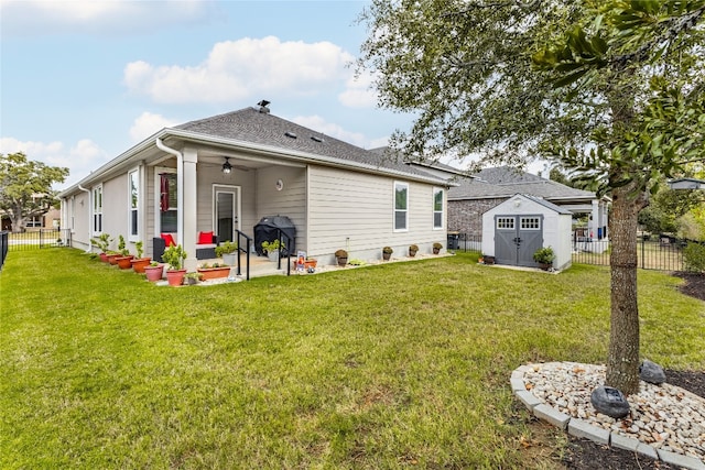 back of house with ceiling fan, a lawn, a storage unit, and a patio area