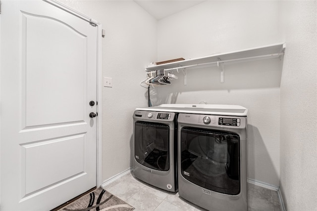 laundry area with light tile patterned floors and washer and clothes dryer