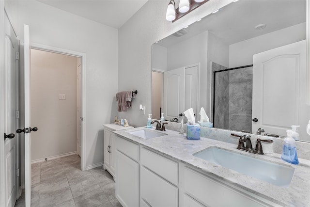 bathroom with vanity, an enclosed shower, and tile patterned floors