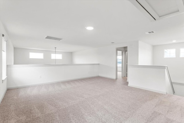 basement with a wealth of natural light and light carpet