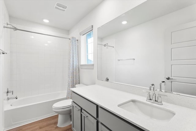 full bathroom with shower / bath combo, vanity, hardwood / wood-style flooring, and toilet