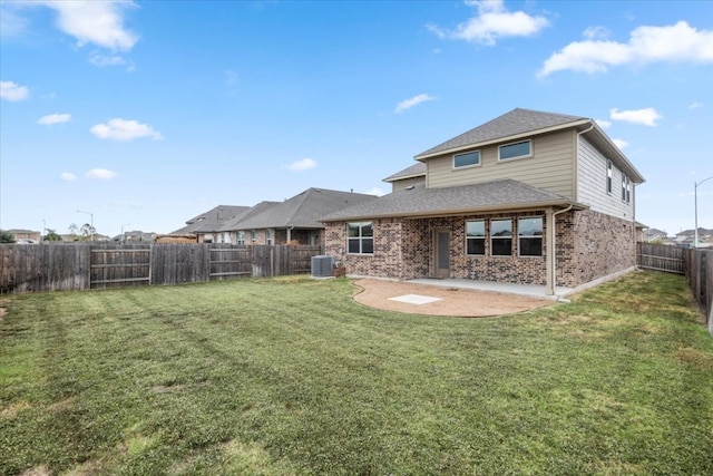 rear view of house featuring central AC unit, a yard, and a patio area