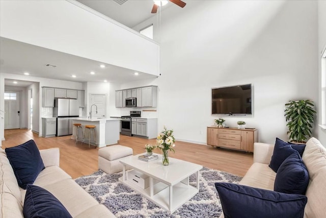 13825 Mc Arthur Dr, Manor, TX 78653 - living room featuring ceiling fan, light wood-type flooring, recessed lighting, and a towering ceiling