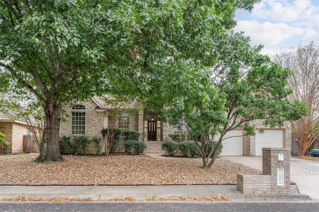 10018 Wild Dunes Dr, Austin, TX 78747 - obstructed view of property with brick siding, concrete driveway, and a garage
