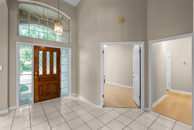 entryway featuring light hardwood / wood-style floors, a high ceiling, and an inviting chandelier