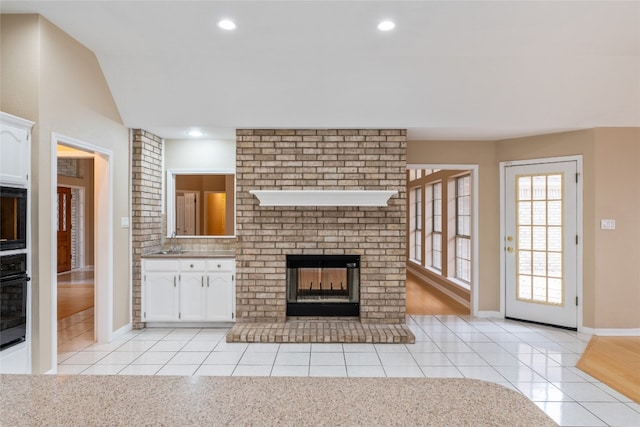 unfurnished living room with a fireplace and light tile patterned flooring