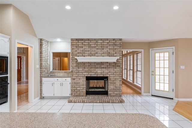 10018 Wild Dunes Dr, Austin, TX 78747 - unfurnished living room with light tile patterned flooring, a fireplace, recessed lighting, and lofted ceiling