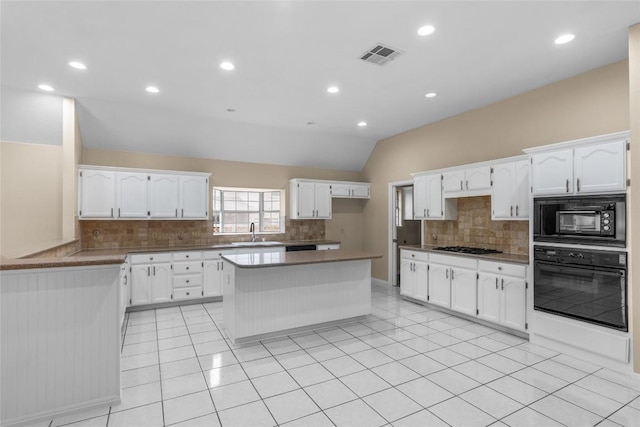 10018 Wild Dunes Dr, Austin, TX 78747 - kitchen with black appliances, tasteful backsplash, vaulted ceiling, white cabinets, and recessed lighting