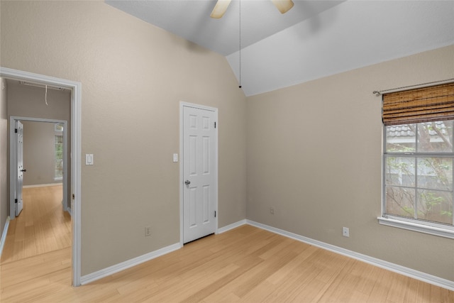 unfurnished bedroom featuring light wood-type flooring, ceiling fan, and vaulted ceiling