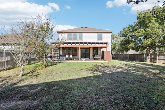 rear view of property featuring a lawn and a patio area