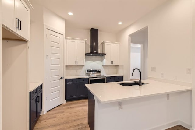 407 Meadowlark St, Austin, TX 78734 - kitchen with wall chimney exhaust hood, stainless steel electric range, a peninsula, light wood-style floors, and white cabinets