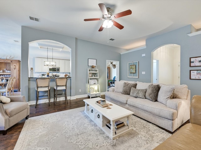 living room featuring ceiling fan with notable chandelier and dark hardwood / wood-style flooring