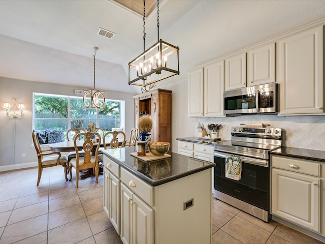 kitchen with stainless steel appliances, light tile patterned flooring, decorative light fixtures, and a kitchen island