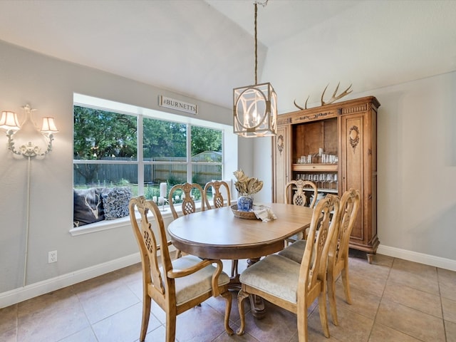 dining room with light tile patterned flooring, a chandelier, and vaulted ceiling