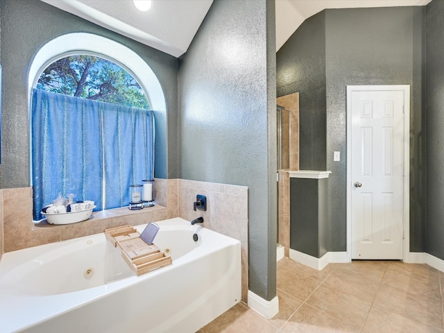 bathroom featuring independent shower and bath, a textured ceiling, tile patterned flooring, and vaulted ceiling