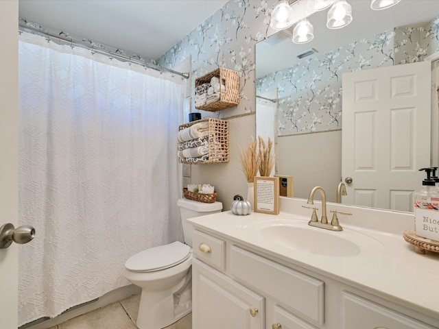 bathroom with toilet, vanity, and tile patterned floors