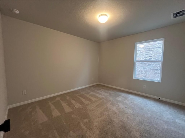 carpeted spare room featuring a textured ceiling