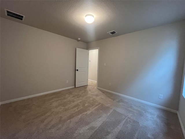 carpeted spare room featuring a textured ceiling