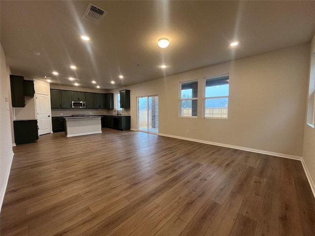 unfurnished living room with dark wood-type flooring