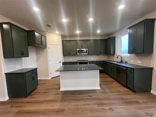 kitchen featuring stainless steel appliances, a center island, sink, and dark hardwood / wood-style flooring