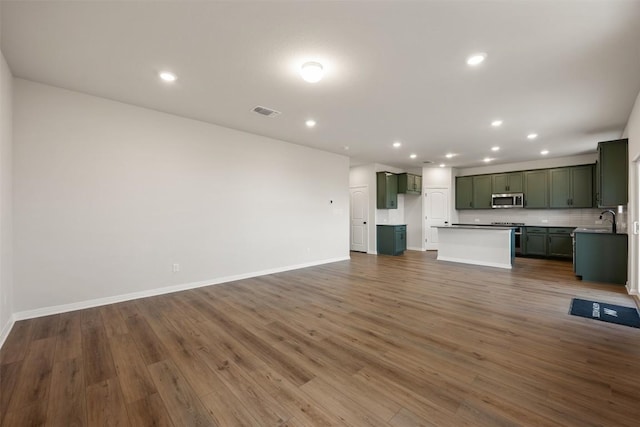 unfurnished living room with sink and dark hardwood / wood-style floors