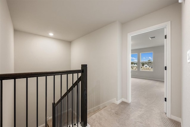 hallway featuring light colored carpet