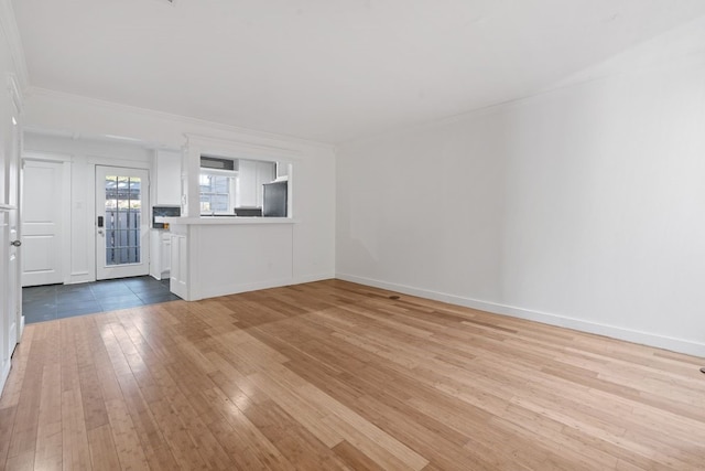 empty room featuring light wood-type flooring and crown molding