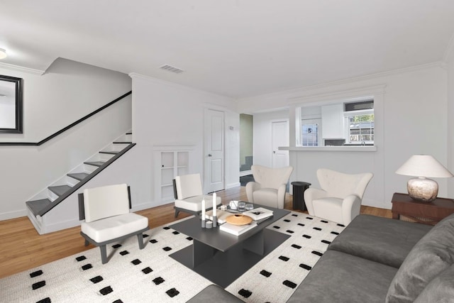 living room with light hardwood / wood-style flooring and ornamental molding