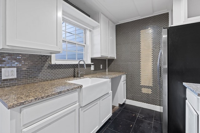 kitchen featuring white cabinets, stainless steel fridge, and sink