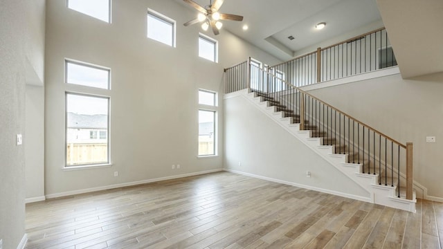 unfurnished living room featuring ceiling fan, a healthy amount of sunlight, and light wood-type flooring