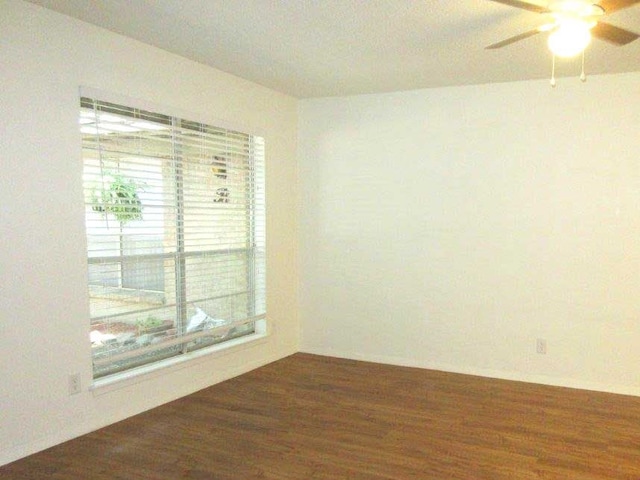 empty room with dark hardwood / wood-style flooring and ceiling fan