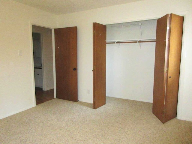 unfurnished bedroom featuring a closet and light carpet